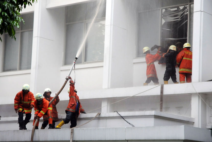   Petugas berusaha memadamkan api kebakaran yang melanda lantai tiga Gedung Sekretariat Negara di Komplek Istana Kepresidenan, Jakarta, Kamis (21/3) sore.