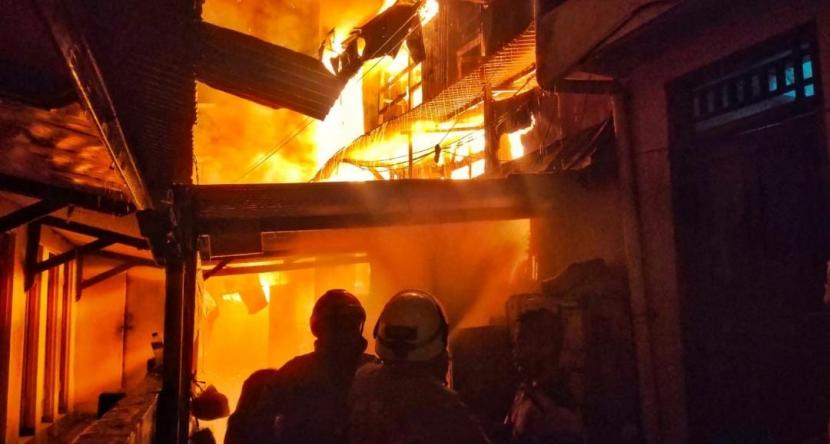 Petugas berusaha memadamkan api yang membakar kawasan Pasar Gembrong RW 01 Kelurahan Cipinang Besar Utara, Kecamatan Jatinegara, Jakarta Timur, Ahad (24/4/2022) malam WIB.
