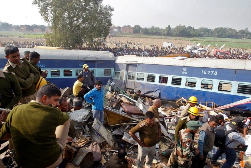 Petugas berusaha mengeluarkan korban kecelakaan kereta api di India.