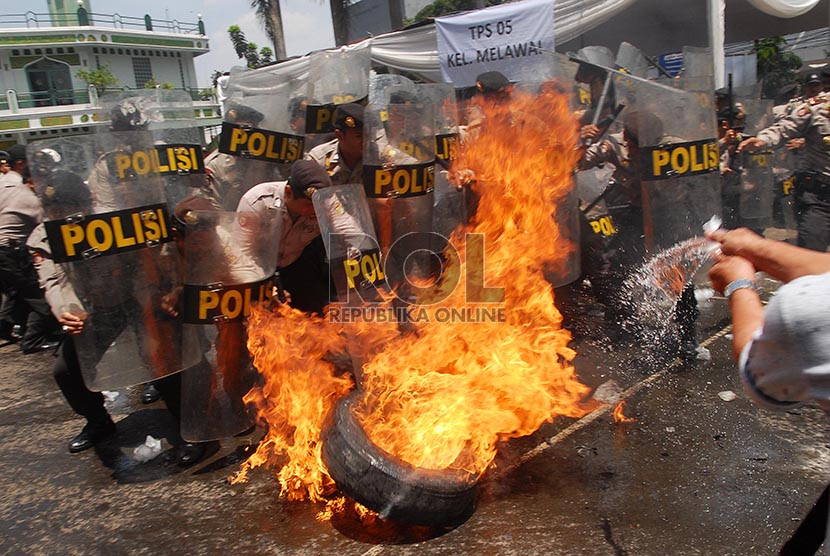 Petugas berusaha menghalau sejumlah pengunjuk rasa pada simulasi pengamanan Pemilu 2014 di Polres Jakarta Selatan, Kamis (20/2).