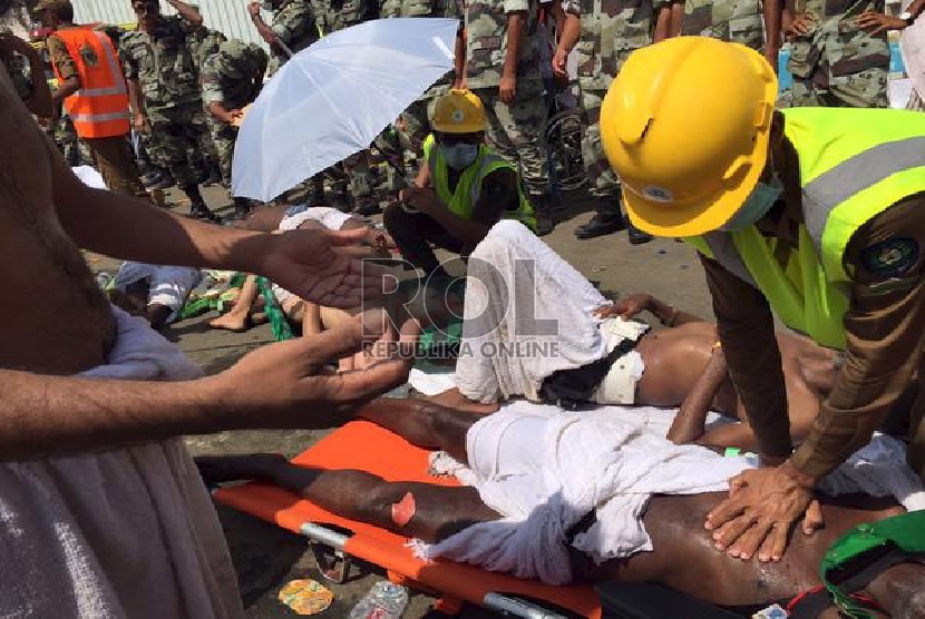 Petugas berusaha menolong jamaah haji yang terluka akibat terinjak-injak di Mina, Kamis (24/9).Reuters