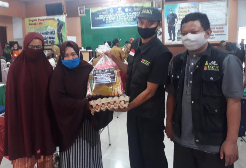 Petugas BMH Perwakilan Sulawesi Tenggara menyerahkan paket new normal kepada perwakilan warga Konawe Utara.