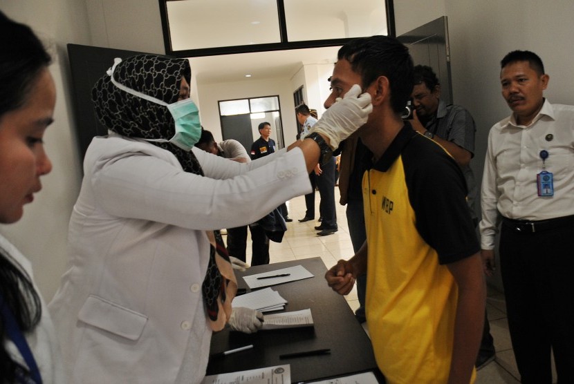 Petugas BNN Kota Depok memeriksa mata seorang warga binaan saat digelar razia narkoba bagi penghuni rutan di Rutan Kelas IIB Depok, Jawa Barat, Senin (14/3).