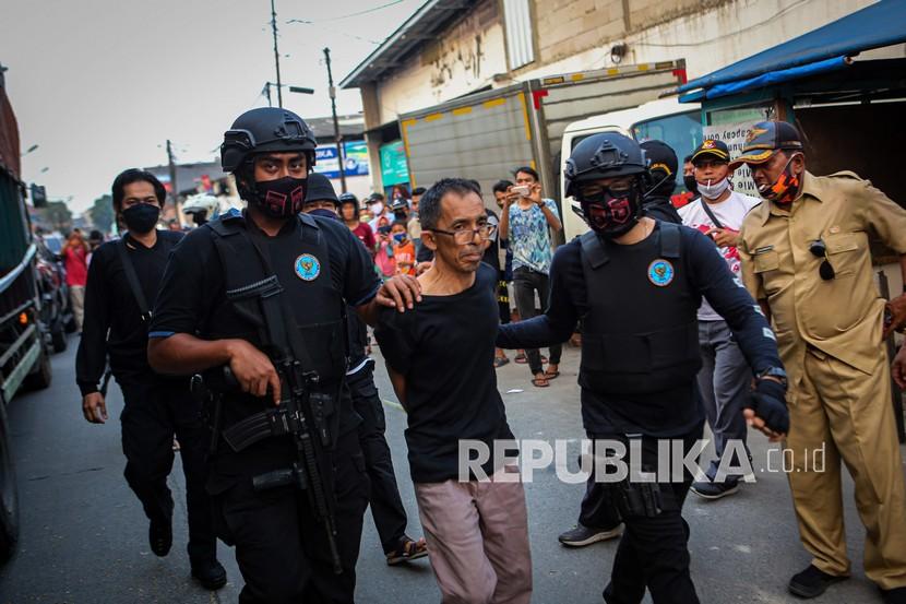 Petugas BNN membawa salah satu tersangka saat penggerebekan penyelundupan narkoba (ilustrasi). Personel Sat Res Narkoba Polres Tanjung Balai bersama instansi terkait Gerebek Kampung Narkoba (GKN) dalam rangka Operasi Antik 2022 di Wilayah Hukum Polres Tanjung Balai, Sumatera Utara.