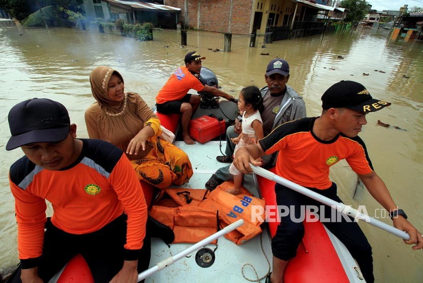 Petugas BNPB mengevakusi warga di tengah banjir di Lhoksukon, Aceh Utara, Aceh, Senin (4/12)