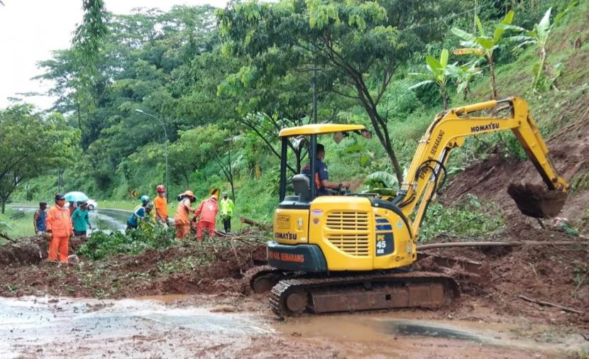 Petugas BPBD Kabupaten Semarang membersihkan material longsor yang menutup badan jalan Jalur Lingkar Ambarawa (JLA), di wilayah Dusun Tegalrejo, Desa/ Kecamatan Bawen, Kabupaten Semarang, Jumat (18/2).