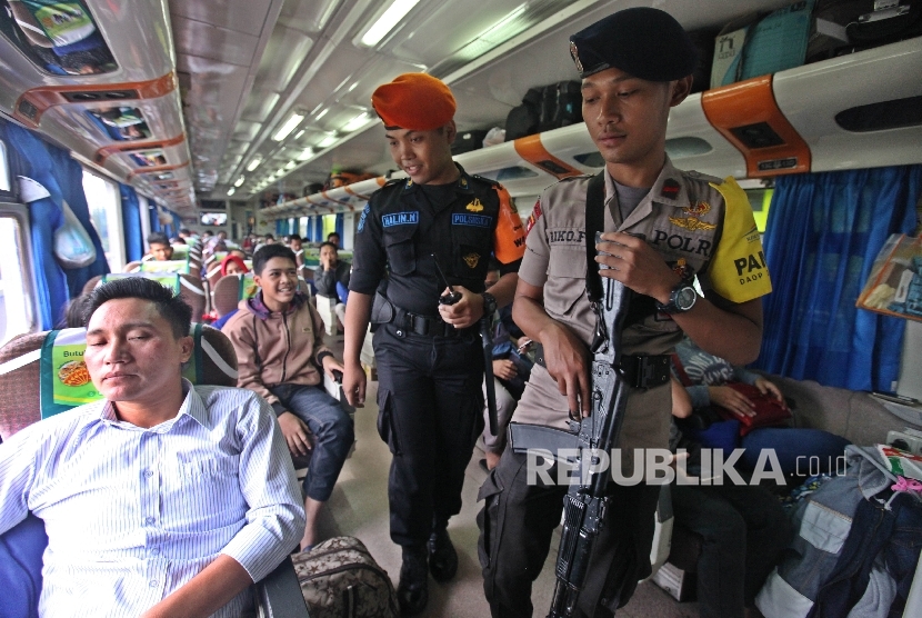 Petugas Brimob bersama Polsuska (Polisi Khusus Kereta Api) berjaga di salah satu gerbong kereta.