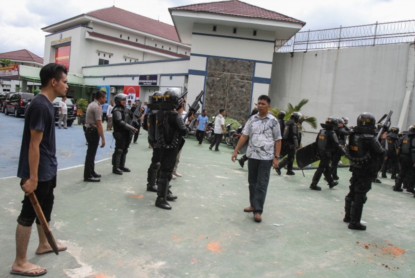 Petugas Brimob Polda Riau bersenjata lengkap dibantu warga berjaga di Rumah Tahanan Sialang Bungkuk Kelas IIB, Pekanbaru, Riau, Jumat (5/5). 