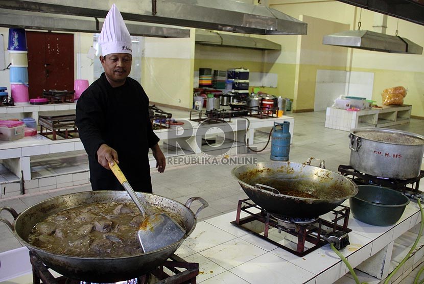 Petugas memasak makanan untuk makan jamaah haji.