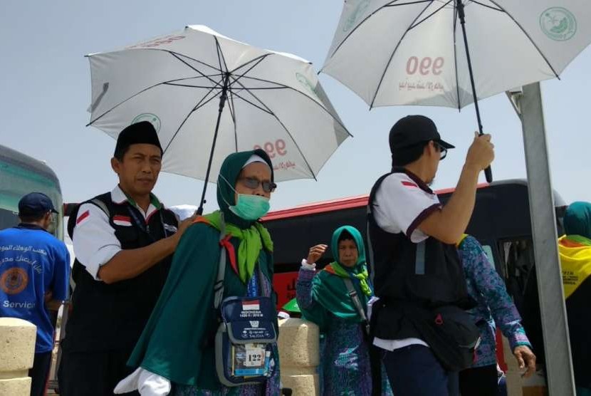 Petugas Daker Bandara memayungi jamaah lansia di Bandara Amir Muhammad bin Abdulaziz, Madinah, Rabu (12/9). 
