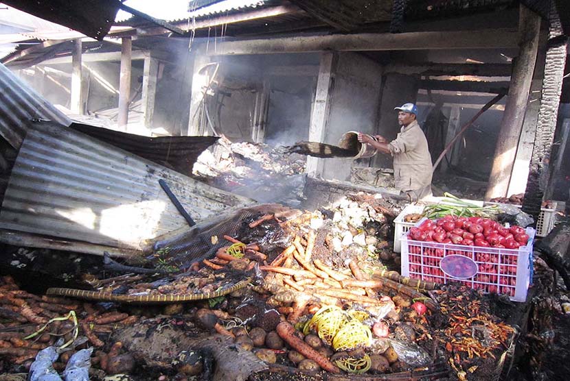 Pemilik kios berusaha memadamkan bara api di Pasar Lembang, Kabupaten Bandung Barat, yang hangus terbakar, Jumat (15/5).  (Republika/Edi Yusuf)