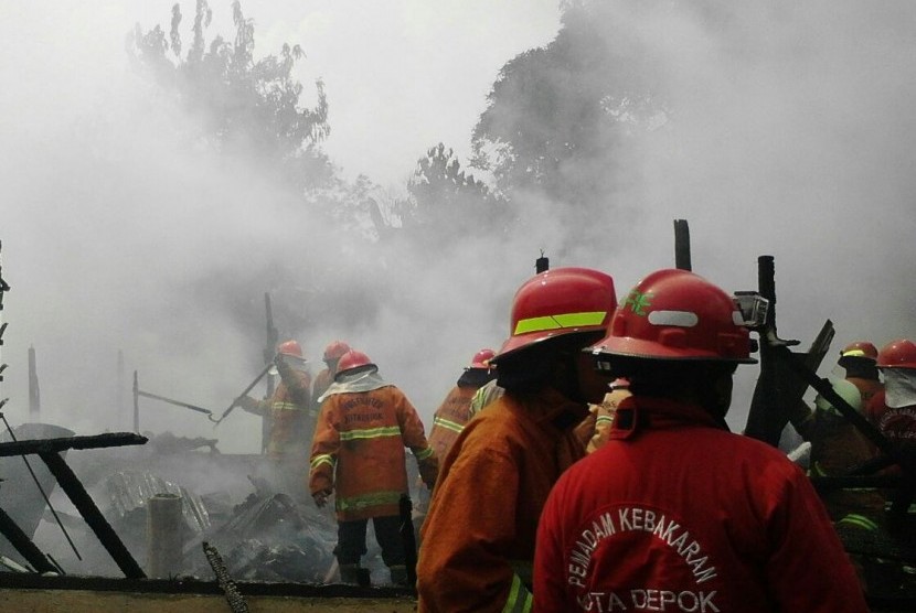 Petugas Damkar Depok memadamkan api yang membakar rumah kontrakan di Kelurahan Gandul, Cinere, Kota Depok, Selasa (10/5) 
