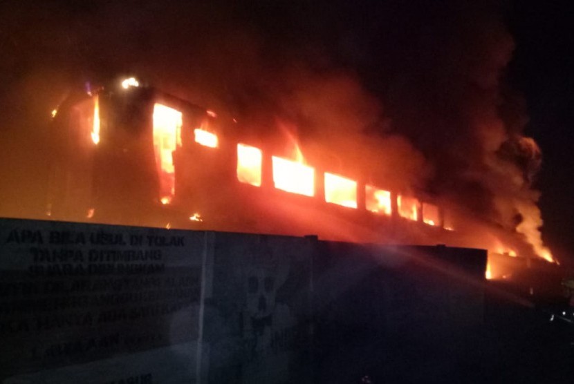 Petugas Damkar Kabupaten Purwakarta, sedang memadamkan api yang membakar 12 bangkai gerbong kereta di sekitaran Stasiun Purwakarta, Sabtu dini hari (6/7). 