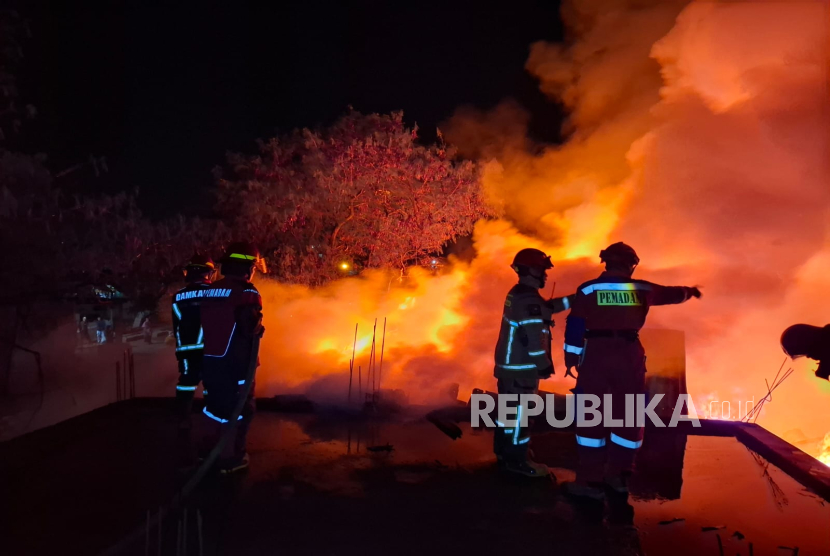 Petugas Damkar Kota Cimahi Tengah Memadamkan Api yang Membakar Sejumlah Gudang di Jalan Sasak Golkar, RW 02, Kelurahan Melong, Kecamatan Cimahi Selatan, Kota Cimahi, Jawa Barat pada Rabu (27/8/2025) sekitar pukul 00.30 WIB. 