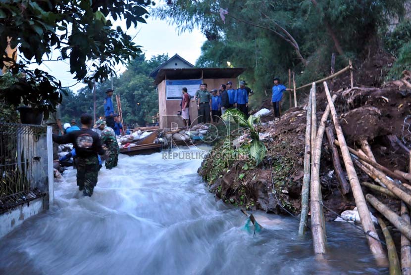  Petugas dan anggota Satgas Banjir Dinas Bina Marga dan Sumber Daya Air Depok masih kesulitan menutup tanggul Kali Laya yang jebol dini hari tadi di kawasan Cimanggis, Depok, Selasa (13/11). (Rakhmawaty La'lang)