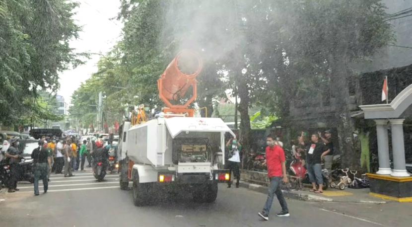 Petugas dan relawan PMI melakukan penyemprotan disinfektan dengan menggunakan mobil blower milik PMI di wilayah Kecamatan Johar Baru, Jakarta Pusat, Sabtu (28/03). PMI akan menerbangkan drone disinfektan di permukiman padat Johar Baru.