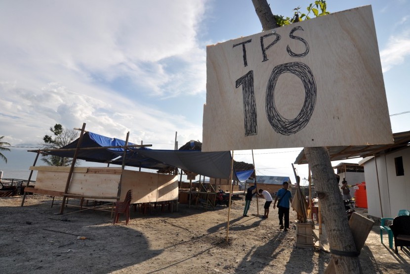 Petugas dan warga bergotong-royong mendirikan tempat pemungutan suara (TPS) di lokasi terdampak bencana gempa dan tsunami di Mamboro, Palu, Sulawesi Tengah, Selasa (16/4/2019).