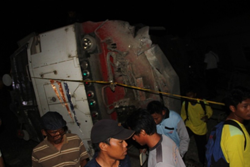 Petugas dan warga melihat lokomotif dari kereta api Eksekutif Bangunkarta jurusan Jakarta Surabaya yang terguling di Mundu, Cirebon, Jawa Barat, Sabtu (23/5) malam.