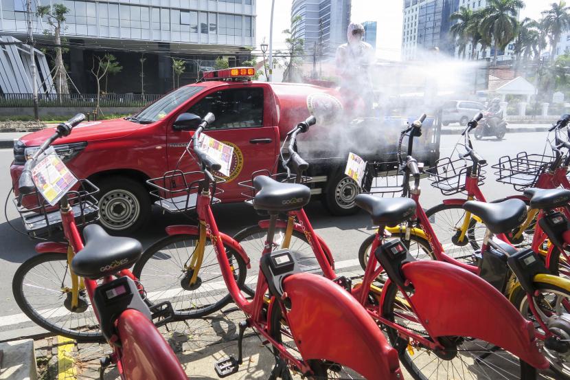 Petugas dari Badan Intelijen Negara (BIN) melakukan penyemprotan cairan disinfektan ke arah sepeda sewa yang berada di Jalan Medan Merdeka Timur, Jakarta (ilustrasi)