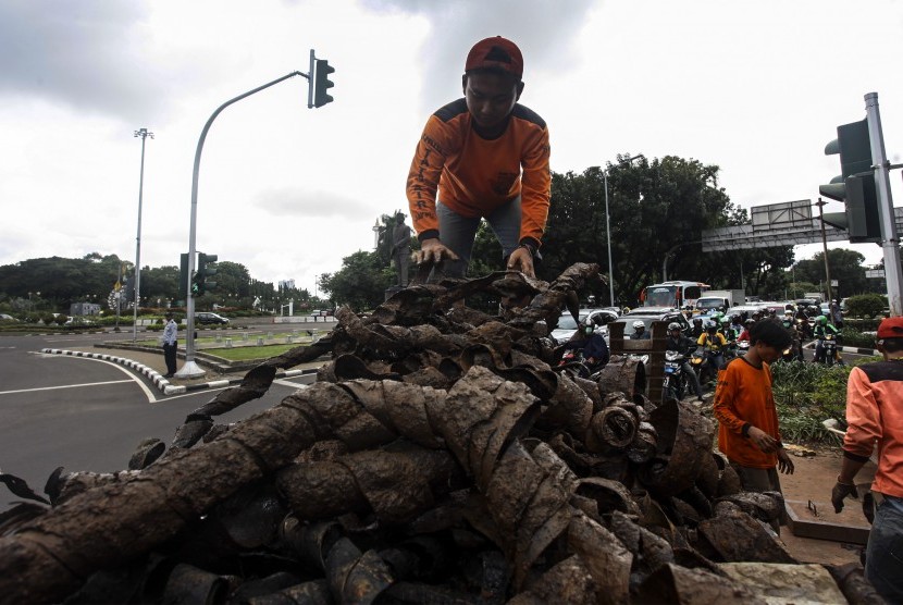 Petugas dari Dinas Kebersihan Pemprov DKI Jakarta mengumpulkan kulit kabel yang diangkat dari dalam gorong-gorong di kawasan Jalan Merdeka Selatan, Jakarta, Jumat (4/3). 