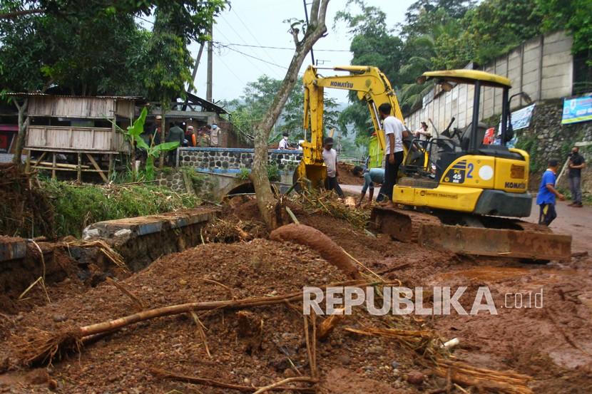 Petugas dari Dinas Pertamanan mengoperasikan alat berat untuk membersihkan puing-puing akibat banjir lumpur di Desa Srigading, Lawang, Malang, Jawa Timur, Rabu (9/3/2022). Hujan deras mengakibatkan enam rumah di Malang ambrol ke aliran Sungai Brantas.