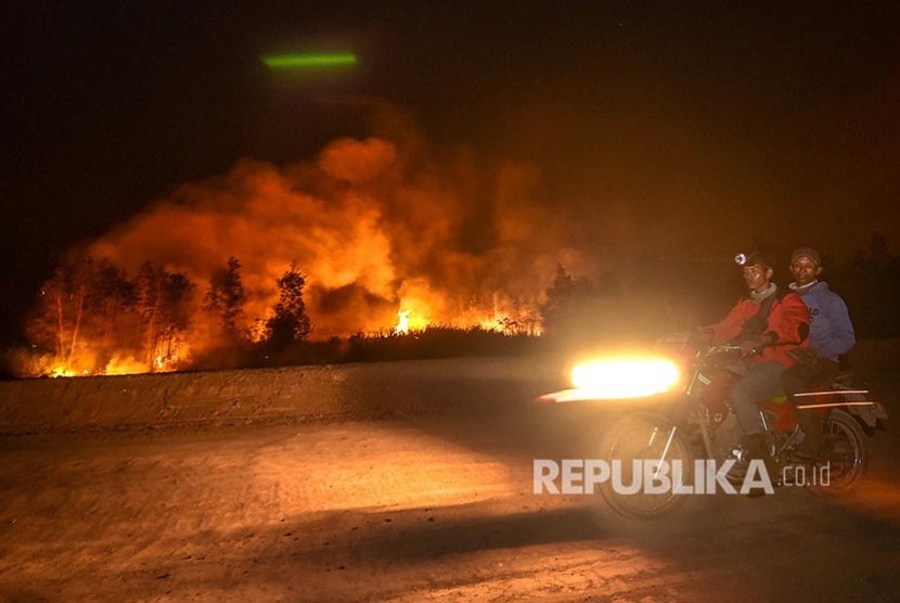 Petugas dari Manggala Agni Daops Banyuasin melintas di lokasi kebakaran lahan di Desa Soak Batok, Indralaya Utara, Ogan Ilir, Sumatera Selatan, Senin (9/9).  Berdasarkan pantauan satelit milik Lembaga Penerbangan dan Antariksa Nasional (LAPAN) terdapat 222 titik panas di Provinsi Sumatera Selatan dan 3335 titik panas yang terdeteksi di sejumlah wilayah yang ada di Indonesia.