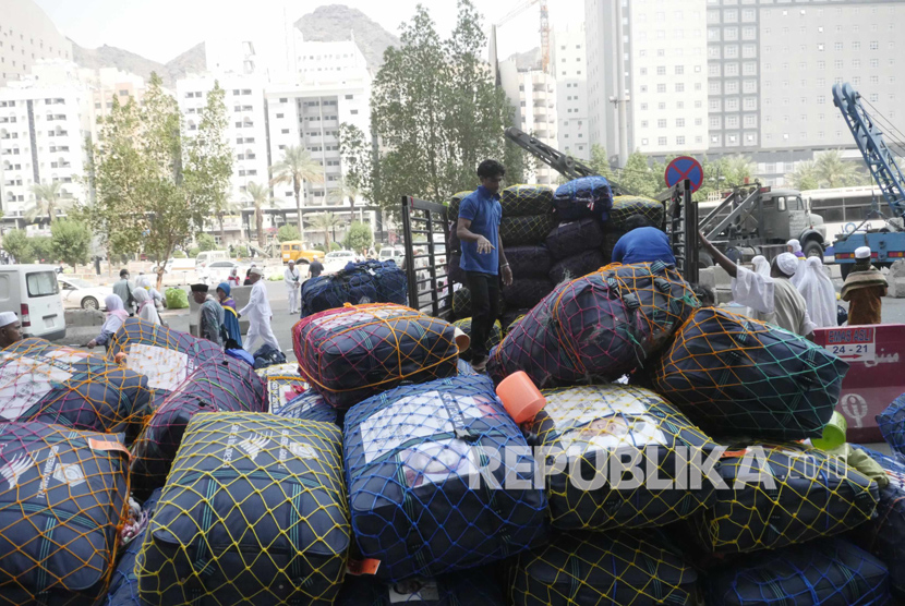 Petugas dari perusahaan kargo menimbang barang milik jamaah haji 