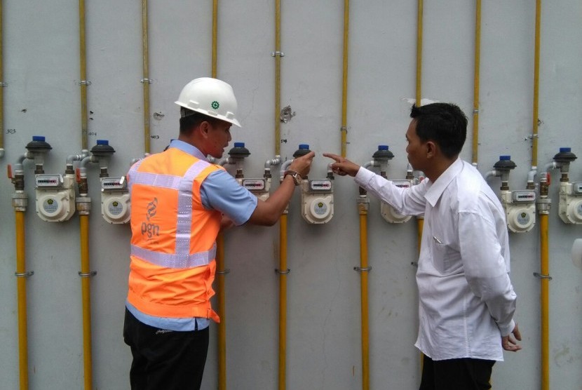 Petugas dari PGN menjelaskan cara kerja gas meter jaringan rumah tangga kepada Ketua RT di Rusun Penjaringan Sari 3, Surabaya, Senin (16/1)