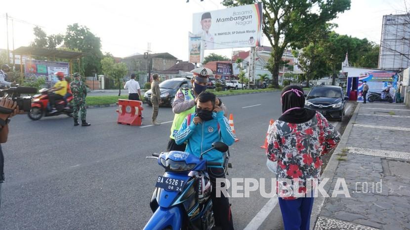 Petugas dari Polri, TNI, Dinas Perhubungan dan Pol PP mengecek kendaraan yang masuk ke Kota Padang di Check Poin depan Basko Padang dalam rangka penerapan Pembatasan Sosial Berskala Besar (PSBB) di Sumbar, Senin (28/4)|