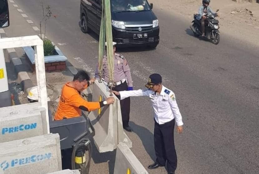 Petugas dari Satuan Lalu lintas Polres Karawang dibantu dari Dinas Perhubungan Karawang, sedang menutup putaran kendaraan (u-turn) di jalan nasional Tanjungpura-Cikampek, dengan menggunakan alat pembatas jalan (ilustrasi). 