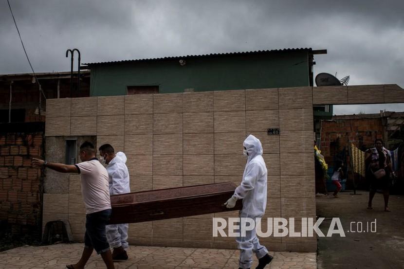 Petugas dari SOS Funeral program of the Municipal Secretariat of Social Assistance melakukan pemindahan jenazah terinfeksi COVID-19 di Manaus, Brasil, Kamis (7/5). Selama Pandemi COVID- 19, Funeral SOS, mengalami peningkatan jumlah bantuan dari penjualan dan donasi guci pemakaman sebesar 300 persen.  