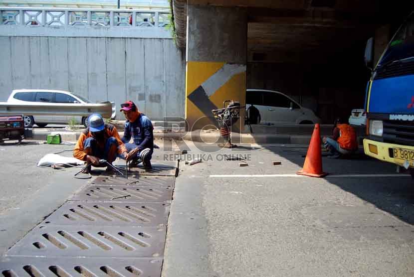 Petugas dari Suku Dinas Pekerjaan Umum Jalan, menyelesaikan perbaikan drill jalan yang jebol di underpass Blok A, Tanah Abang, Jakarta Pusat, Selasa (15/7). (Republika/Raisan Al Farisi)
