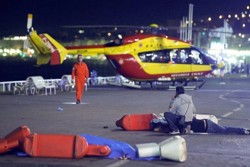 Petugas darurat membantu menyelamatkan korban terluka serangan truk di Nice, Prancis, Kamis malam (14/7).