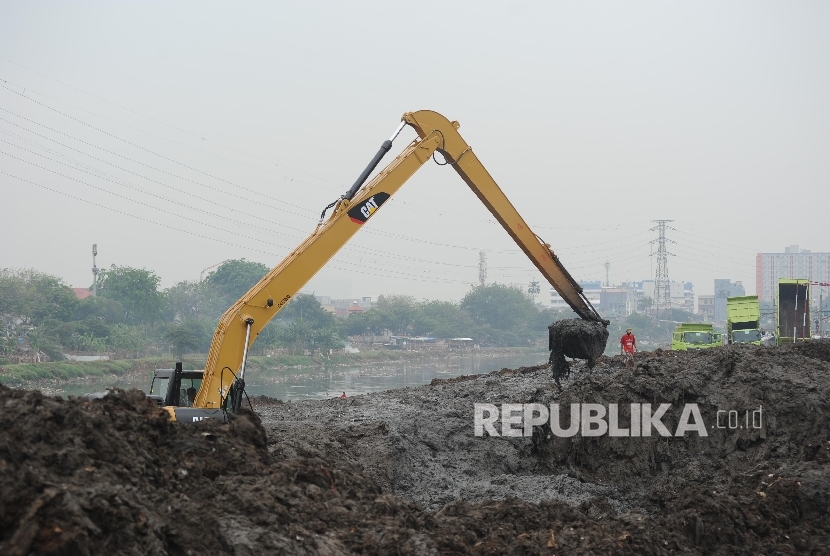 Petugas dengan alat berat mengeruk endapan lumpur di sungai Ciliwung di kawasan Banjir Kanal Barat (BKB), Jakarta, Ahad  (24/9). 