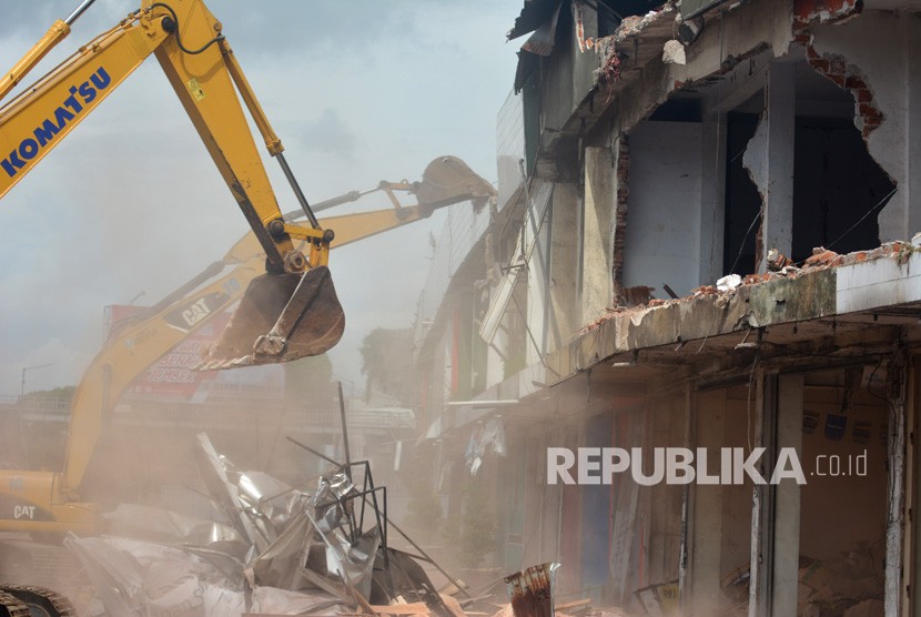 Petugas dengan alat berat merobohkan bangunan Pertokoan Jompo yang rawan ambruk di Kaliwates, Jember, Jawa Timur, Rabu (4/3/2020).