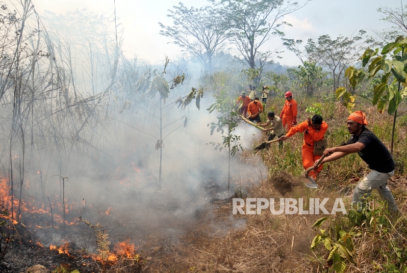 Petugas di bantu warga sekitar memadamkan api dilahan gambut Lereng Gunung Ciremai, Jawa Barat, Sabtu (12/9). 