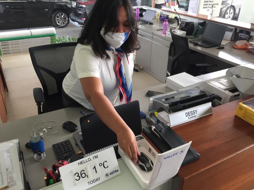Petugas di dealer BMW Astra Cilandak Jakarta tengah melakukan pembersihan kunci mobil dan peralatan makan menggunakan sterilizer box. 