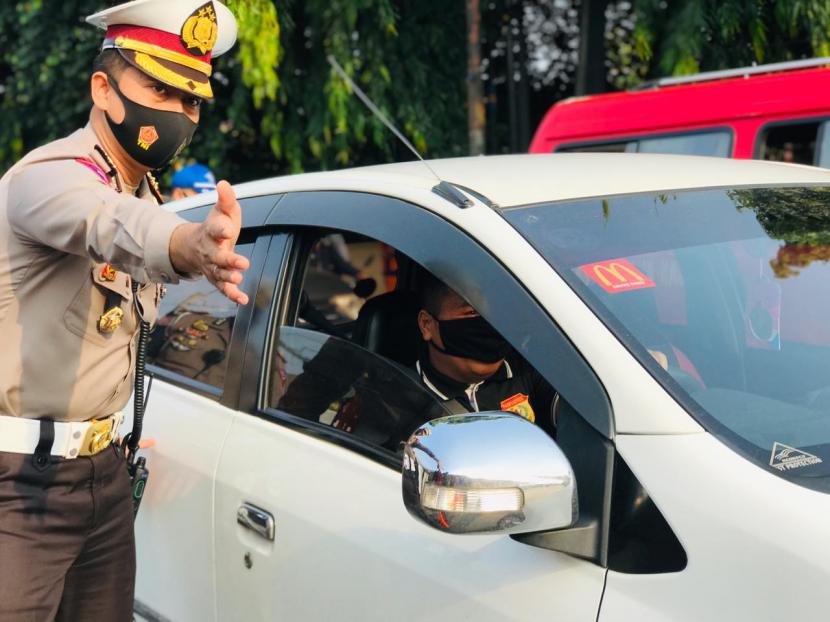 Petugas di Pos Pantau Operasi Yustisi meminta penumpang kendaraan roda empat untuk memakai maskernya dengan benar di pos pantau Pasar Juma, Senin (14/9).