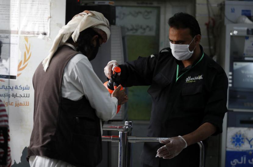 Petugas di Yaman menyemprotkan hand sanitizer kepada seorang pria. Yaman saat ini tengah dilanda kelaparan dan penyakit akibat perang yang berkecamuk.