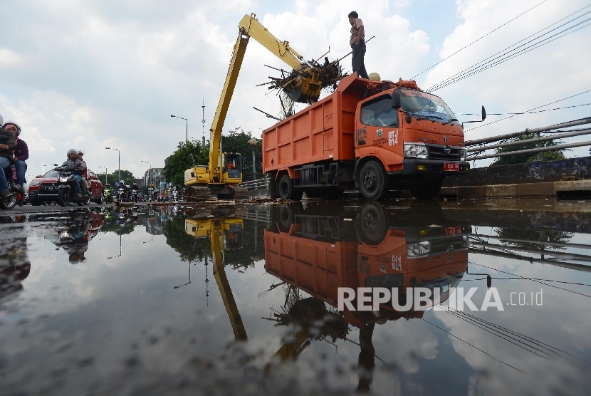  Petugas dibantu alat berat mengangkut sampah yang mengendap di Sungai Ciliwung Kawasan Kampung Melayu, Jakarta Timur, Ahad (3/4). (Republika/Raisan Al Farisi)