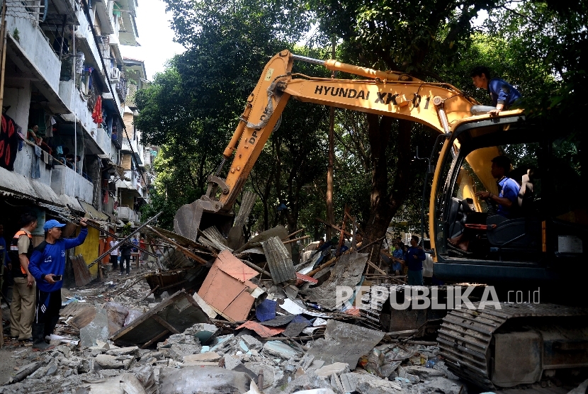 Petugas dibantu dengan alat berat membongkar bangunan semi permanen ketika penertiban bangunan liar di area Rusun Bidara Cina, Jatinegara, Jakarta, Kamis (14/9).