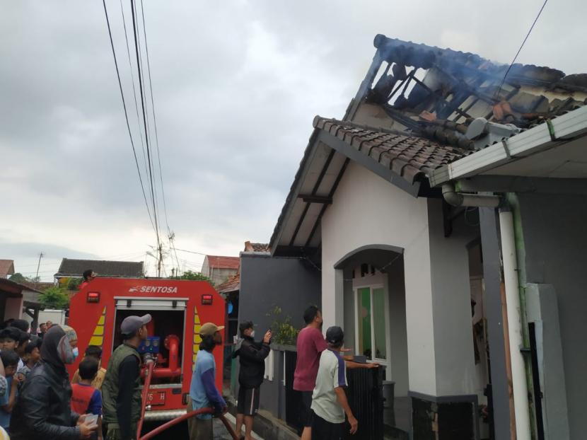 Petugas dibantu warga berupaya memadamkan api di lokasi kebakaran, Perum Cisalak, Kecamatan Cipedes, Kota Tasikmalaya, Ahad (10/10).