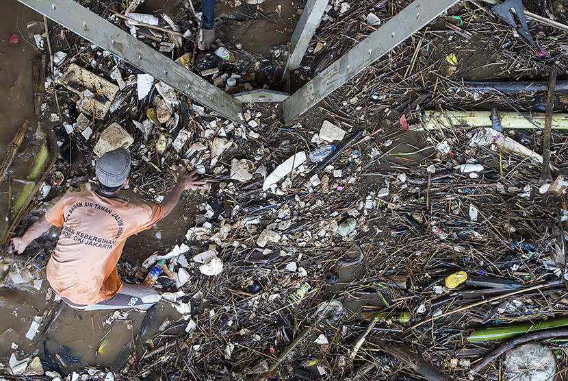 Petugas Dinas Kebersihan DKI Jakarta membersihkan sampah yang terbawa arus Sungai Ciliwung dan tersangkut di Jembatan Kalibata, Jakarta Selatan, Rabu (25/11).