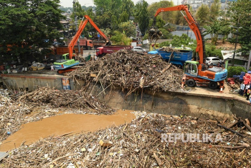 Petugas Dinas Kebersihan DKI Jakarta menggunakan alat berat membersihkan sampah di pintu air Manggarai, Jakarta. (Ilustrasi)