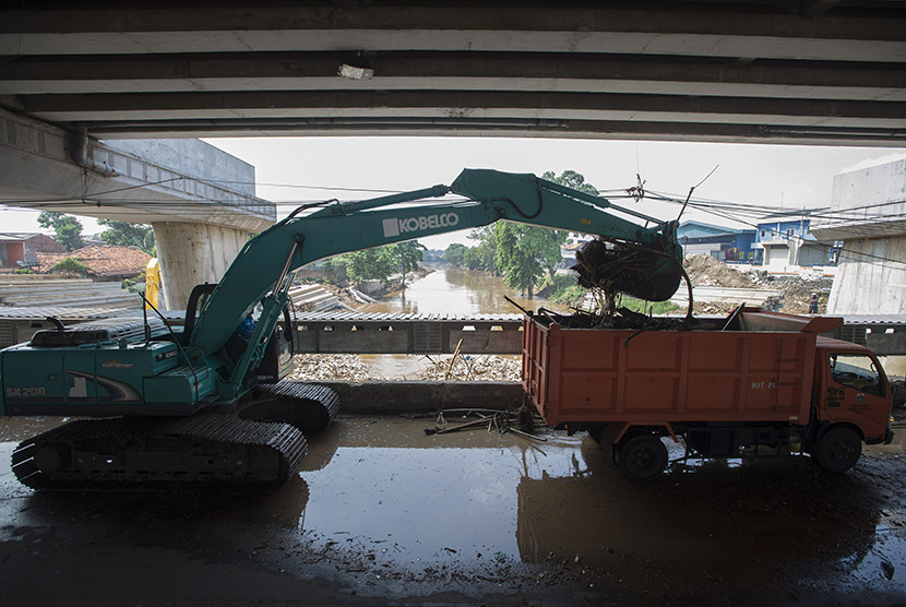 Petugas Dinas Kebersihan DKI Jakarta mengoperasikan ekskavator untuk memindahkan sampah yang terbawa arus Sungai Ciliwung. (Ilustrasi)