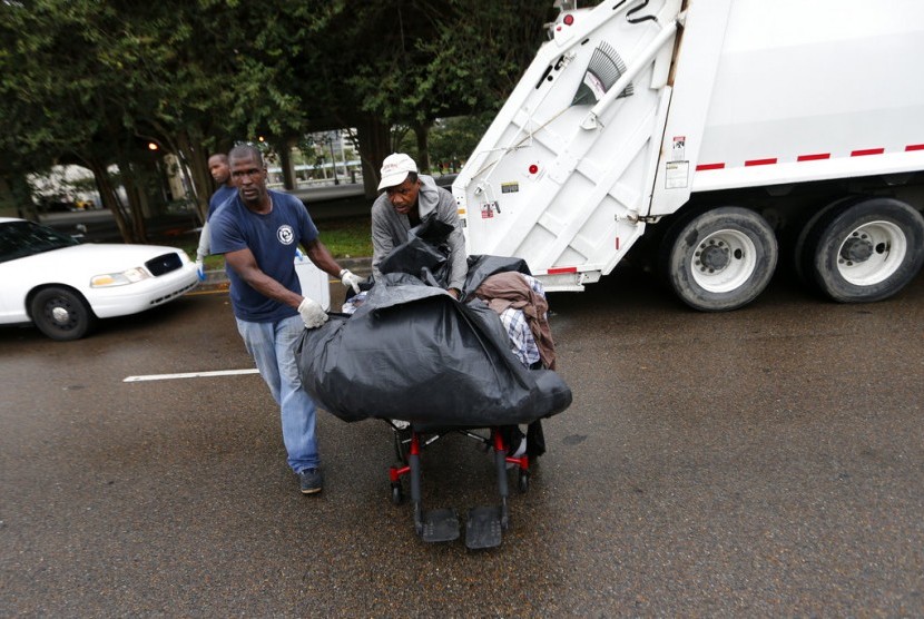 Petugas dinas kebersihan membantu warga tunawisma mengevakuasi diri jelang Topan Nate di New Orleans, (8/10).