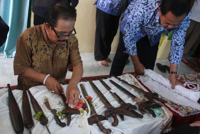  Petugas Dinas Kebudayaan dan Pariwisata memeriksa senjata berupa keris, tombak, dan pedang peninggalan purbakala yang baru diserahkan seorang warga di Desa Jeru, Tumpang, Malang, Jawa Timur, Kamis (17/3). 