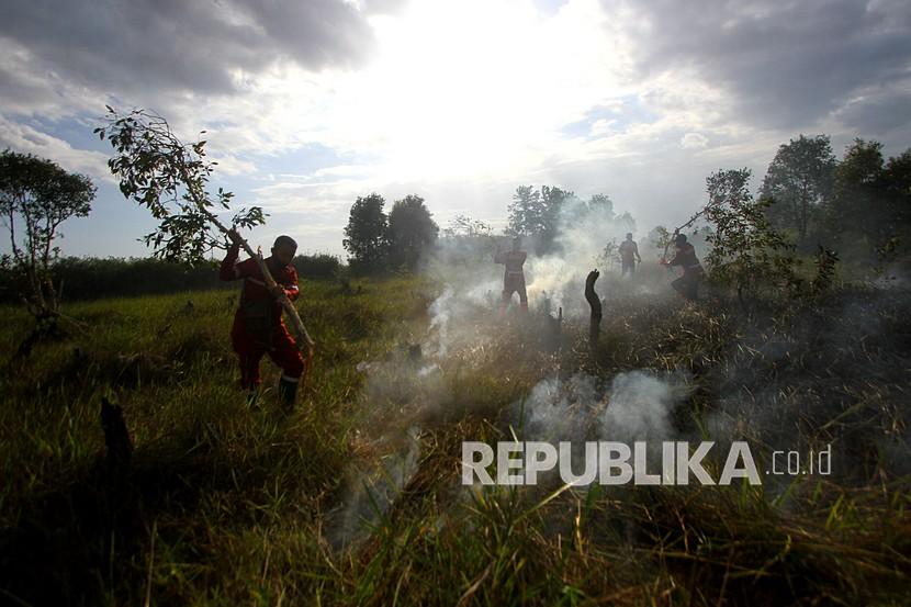 Petugas Dinas Kehutanan Provinsi Kalsel berusaha memadamkan kebakaran lahan gambut di Kawasan Liang Anggang, Banjarbaru, Kalimantan Selatan, Kamis (27/8/2020). Petugas gabungan yang terdiri dari Dinas Kehutanan, Manggala Agni, serta dua helikopter milik Badan Nasional Penanggulangan Bencana (BNPB) dikerahkan untuk memadamkan kebakaran lahan gambut tersebut.