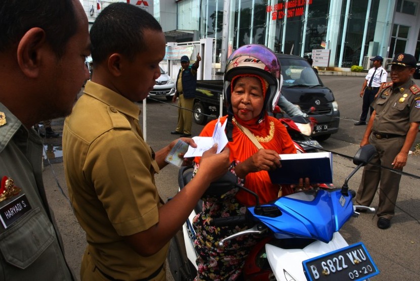 Petugas Dinas Kependudukan dan Pencatatan Sipil (Dukcapil) bersama petugas Satpol PP Kota memeriksa kartu identitas berupa KTP pengendara dalam operasi Yustisi.