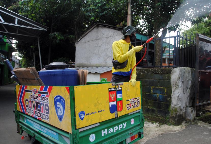 Petugas Dinas Lingkungan Hidup (DLH) Kota Bogor menyemprotkan cairan disinfektan di lingkungan sekitar Pondok Pesantren (Ponpes) Bina Madani di Kelurahan Harjasari, Kota Bogor, Jawa Barat, Selasa (8/6/2021). 